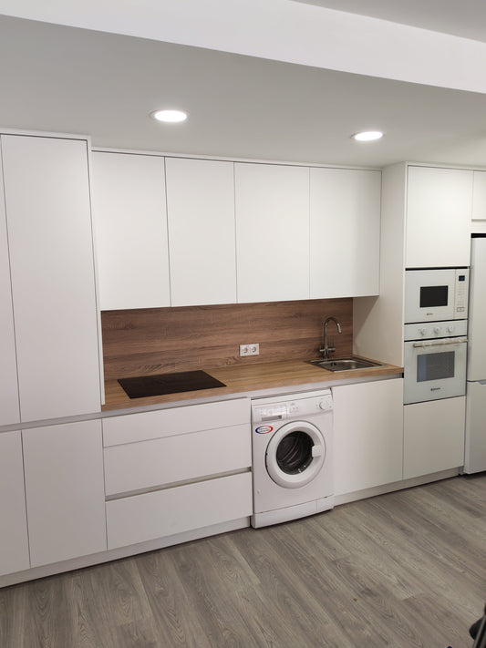 Cocina blanca mate con encimera de madera roble instalada en Roquetas de Mar por JAM MUEBLES Almería